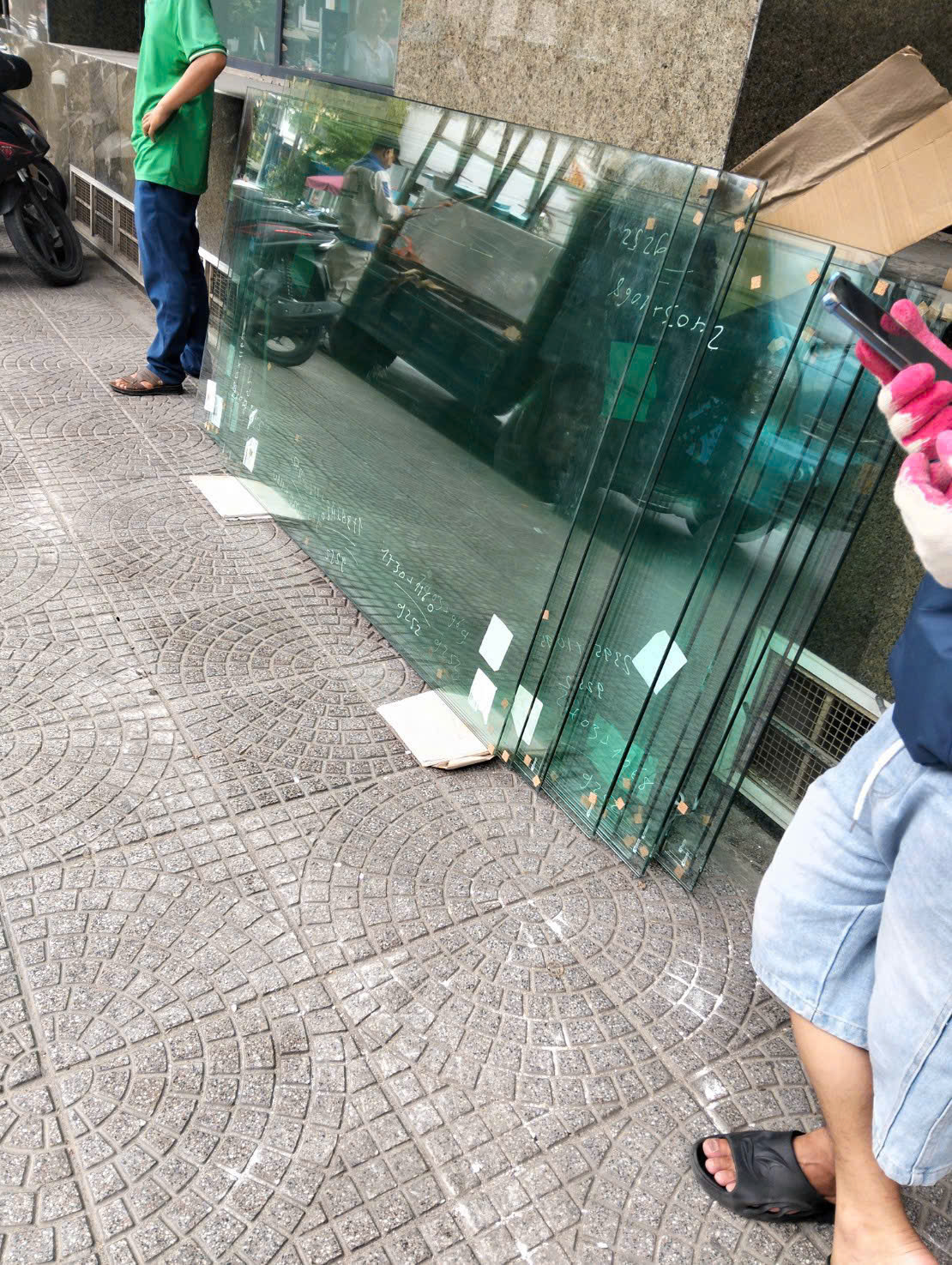 Kính công trình được xếp dựng trên vỉa hè để chuẩn bị lắp đặt